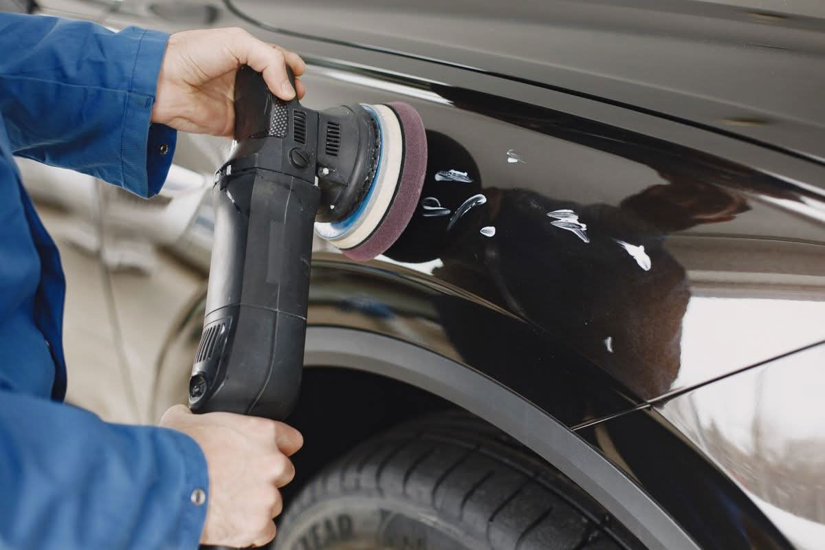 How to Choose the Right Auto Paint Repair Service in Willamette Valley 1 Hands using a polishing machine on a car's painted surface