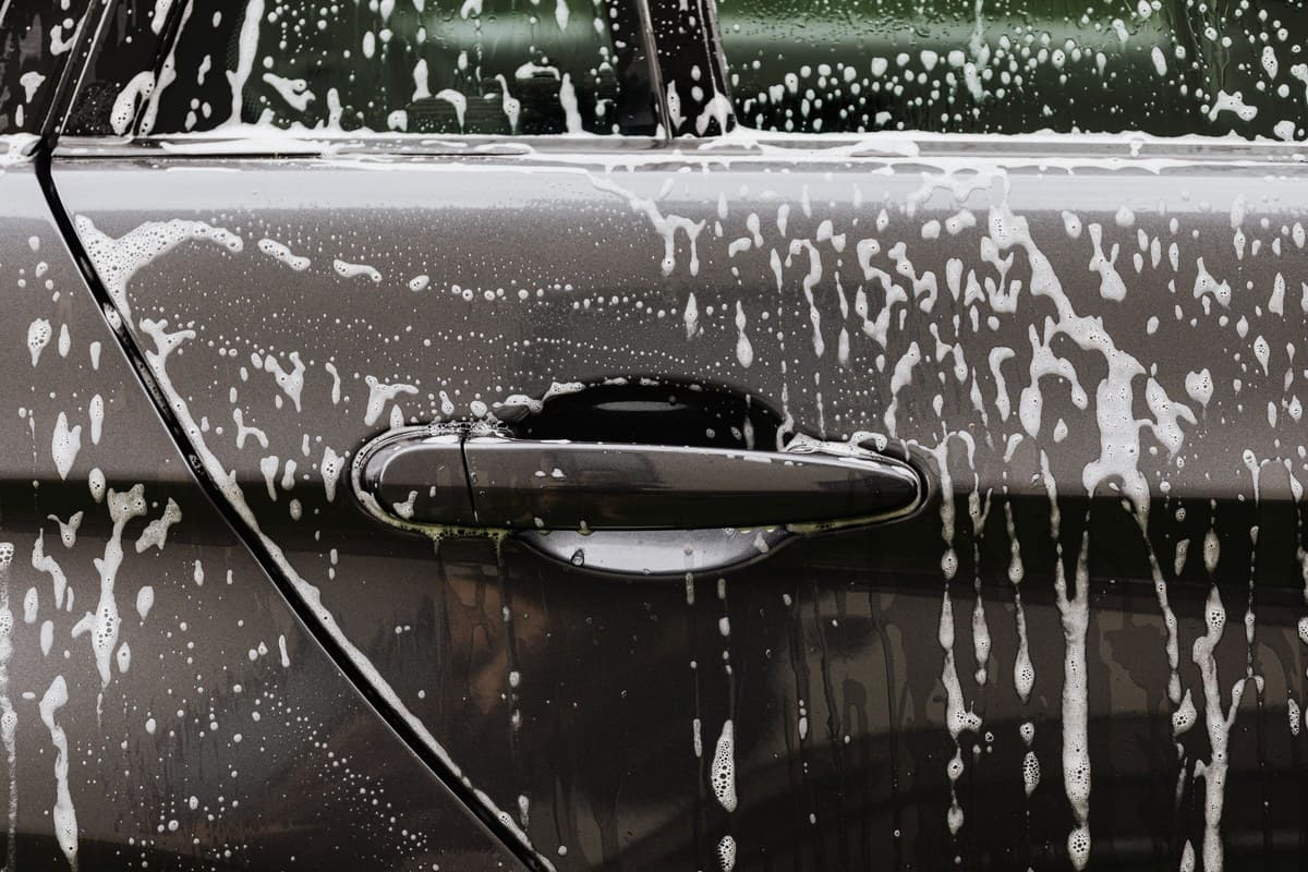 How to Keep Your Car's Paint Looking New in Willamette Valley 3 Soap suds rinsing down a car door panel during a hand wash to protect the paint finish