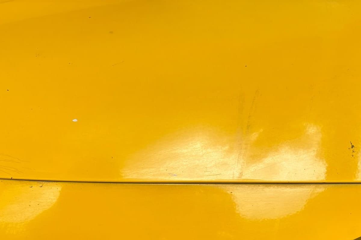 Common Types of Car Paint Damage and How to Fix Them 3 Close-up of light surface scratches and swirl marks on a cars glossy yellow paint