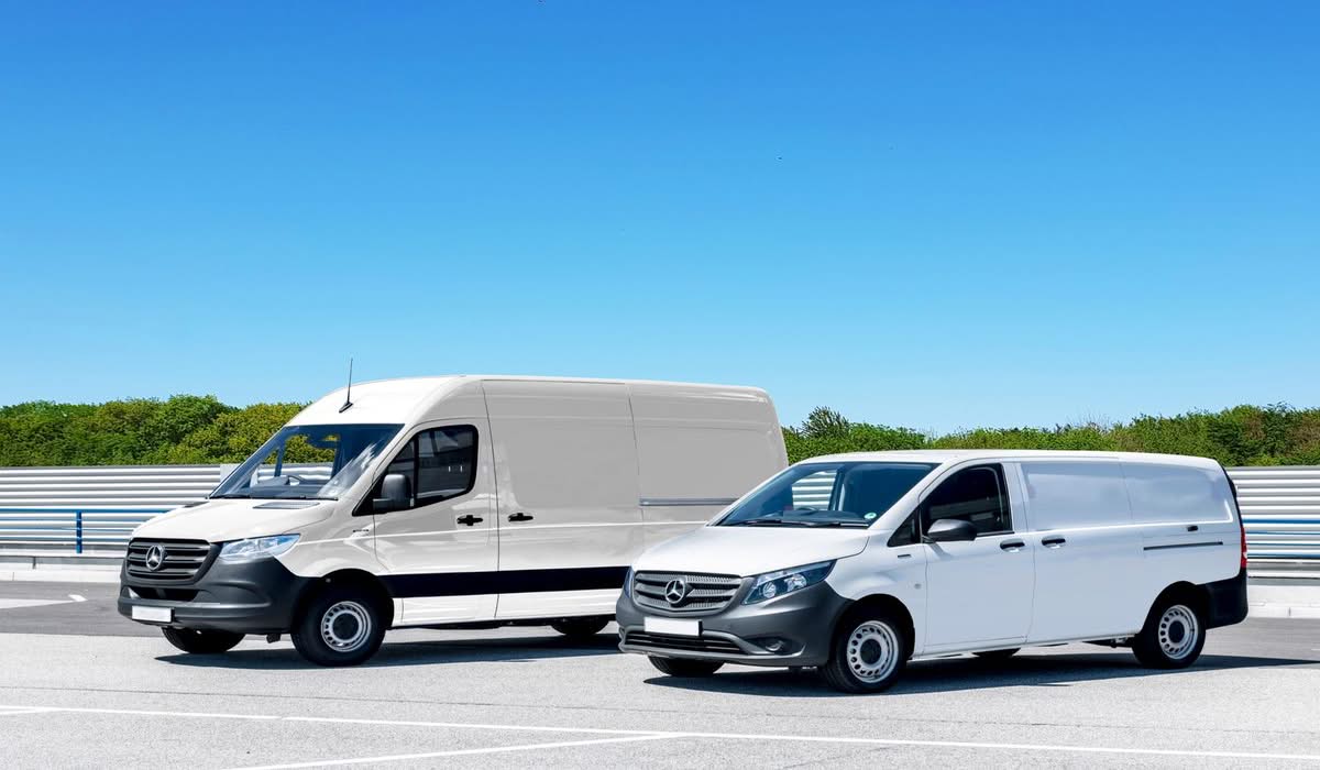 Two plain white commercial cargo vans parked side by side
