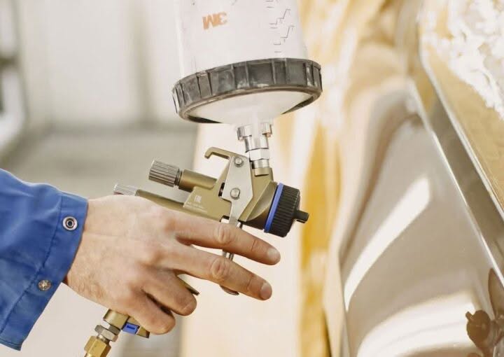 Mobile technician applying automotive paint touch-up with a spray gun