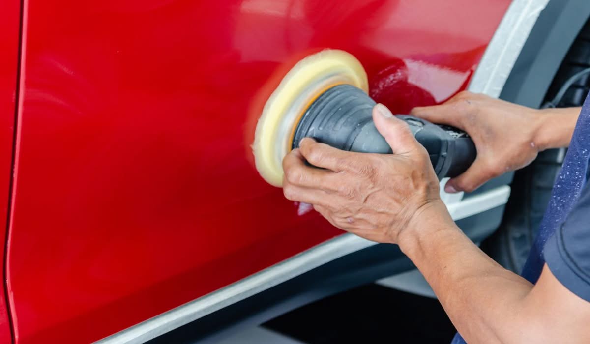 Technician buffing and polishing car paint to restore shine