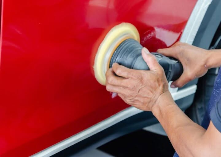 Technician buffing and polishing car paint to restore shine