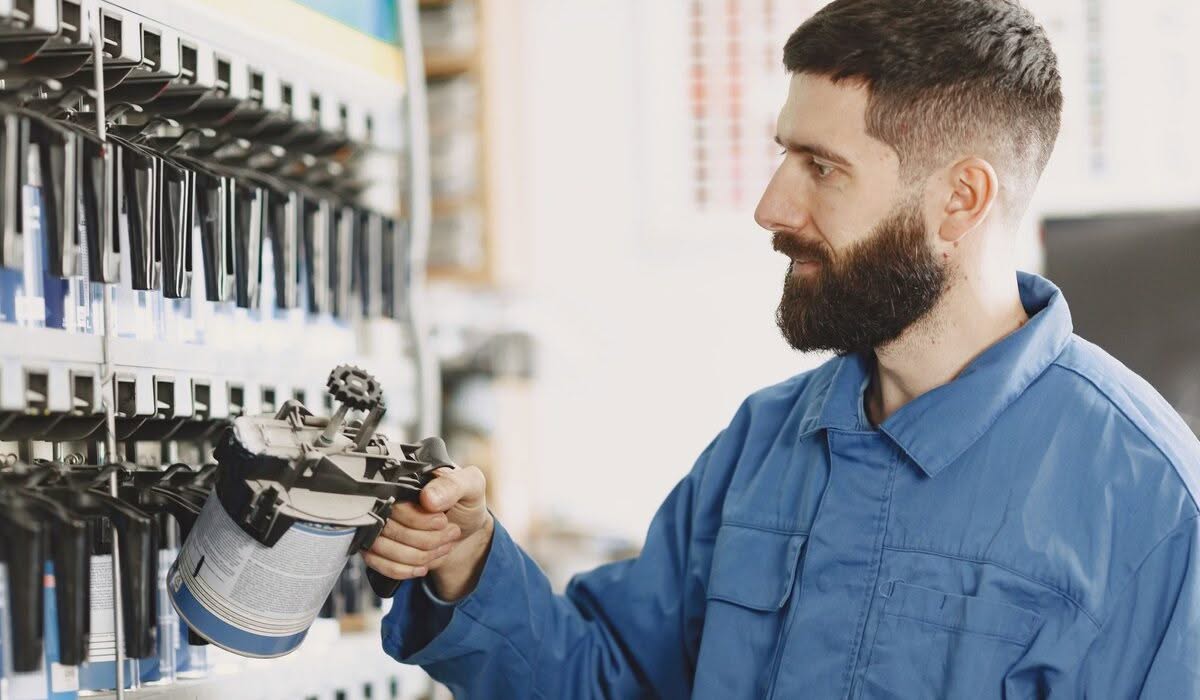 Auto paint technician selecting the correct factory color match at a paint mixing station