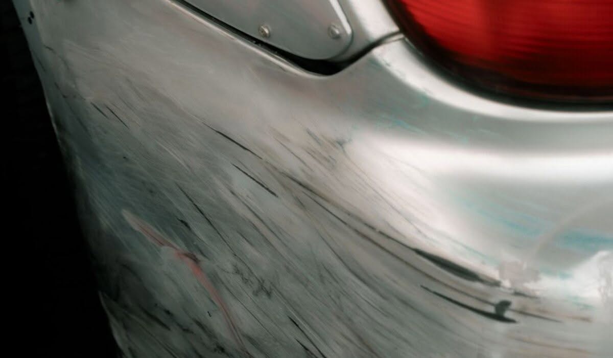 Bumper Scuffs and Panel Damage: What Are Your Repair Options? 1 Close-up of scuff and paint transfer marks on a car bumper corner near the taillight
